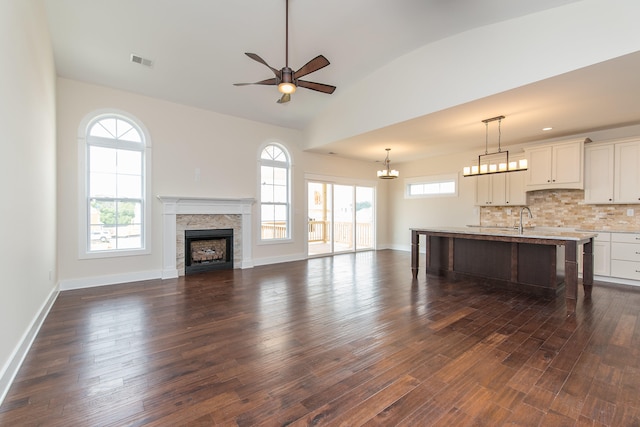 4185 Buttermilk Rd, Lexington, KY 40509 - unfurnished living room featuring a ceiling fan, a fireplace, dark wood-style floors, vaulted ceiling, and a chandelier