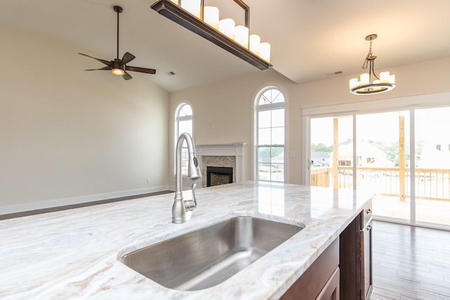 4185 Buttermilk Rd, Lexington, KY 40509 - kitchen featuring open floor plan, decorative light fixtures, wood finished floors, a fireplace, and a chandelier