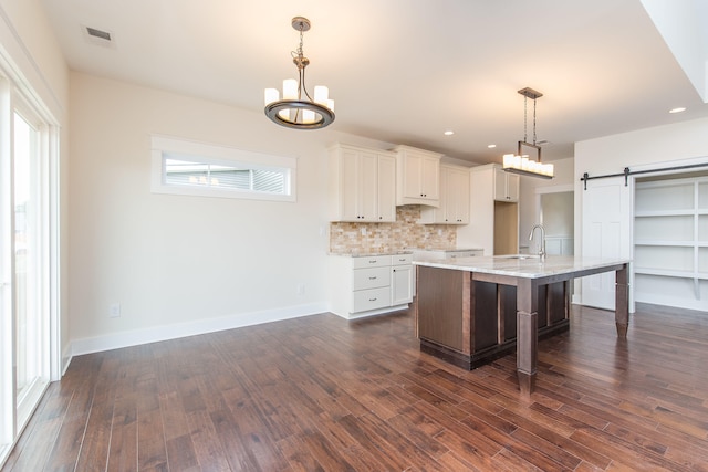 4185 Buttermilk Rd, Lexington, KY 40509 - kitchen featuring a chandelier, a barn door, dark wood-type flooring, white cabinets, and backsplash