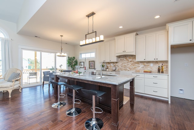 4185 Buttermilk Rd, Lexington, KY 40509 - kitchen featuring decorative backsplash, pendant lighting, white cabinets, dark wood-style flooring, and light stone countertops