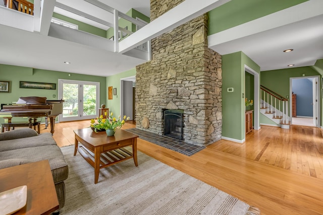 2968 Delong Rd, Lexington, KY 40515 - living room featuring wood finished floors, a stone fireplace, a towering ceiling, and stairs