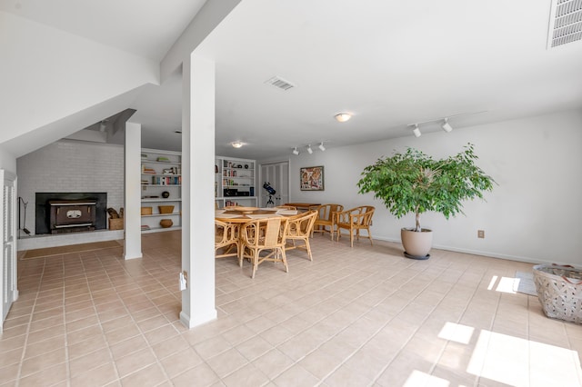 2968 Delong Rd, Lexington, KY 40515 - dining space with light tile patterned floors, a wood stove, track lighting, and built in features