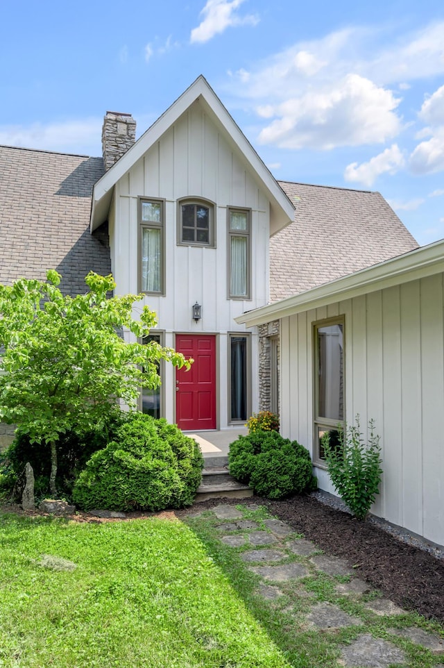 2968 Delong Rd, Lexington, KY 40515 - view of front of house with a chimney, board and batten siding, roof with shingles, and a front lawn
