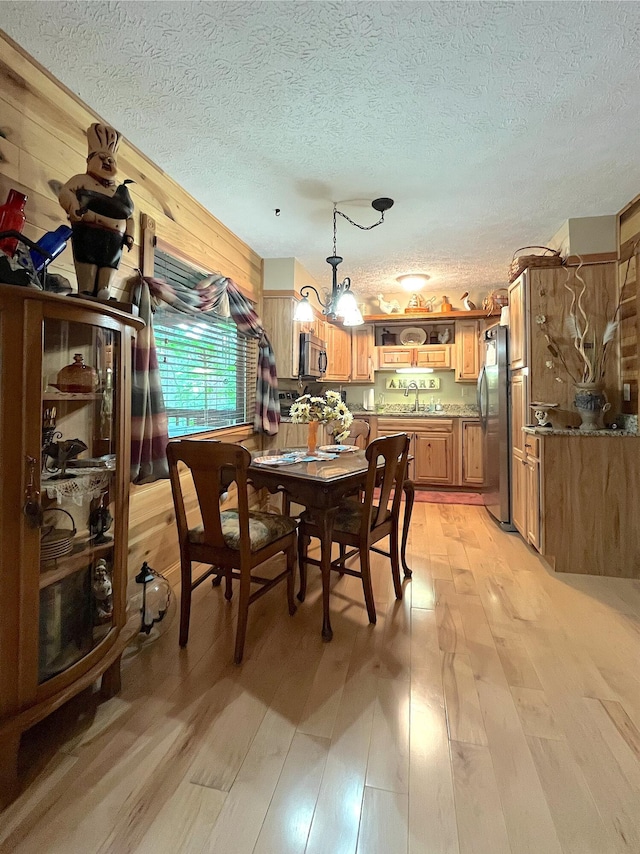 250 Hilltop Ests, Morehead, KY 40351 - dining space featuring light wood-type flooring, a textured ceiling, and wood walls