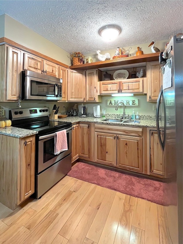 250 Hilltop Ests, Morehead, KY 40351 - kitchen featuring stainless steel appliances, light wood-style floors, light stone counters, and a textured ceiling