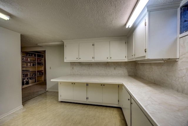 560 Kemper Ln, Danville, KY 40422 - kitchen with a textured ceiling, light countertops, decorative backsplash, light flooring, and white cabinetry