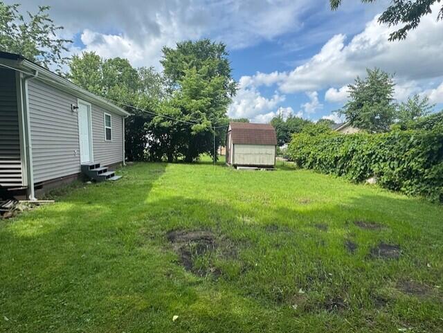 524 Clark St, Danville, KY 40422 - view of green lawn with entry steps and a storage unit