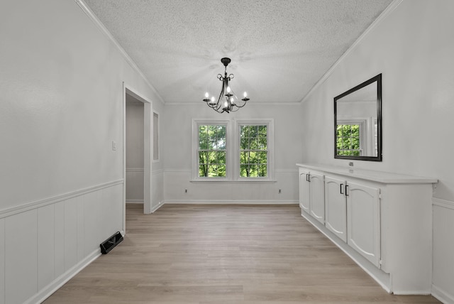 4822 US Highway 27 N, Cynthiana, KY 41031 - unfurnished dining area with a textured ceiling, ornamental molding, a chandelier, light wood-type flooring, and wainscoting