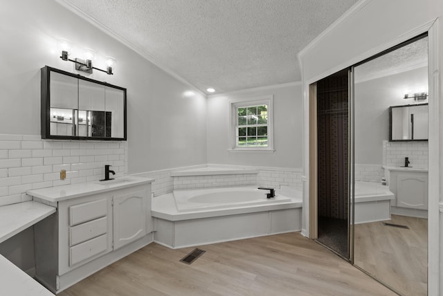 4822 US Highway 27 N, Cynthiana, KY 41031 - bathroom featuring a textured ceiling, ornamental molding, wood finished floors, a bath, and two vanities