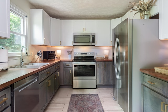1424 Corral Way, Frankfort, KY 40601 - kitchen featuring stainless steel appliances, white cabinetry, a textured ceiling, and dark countertops
