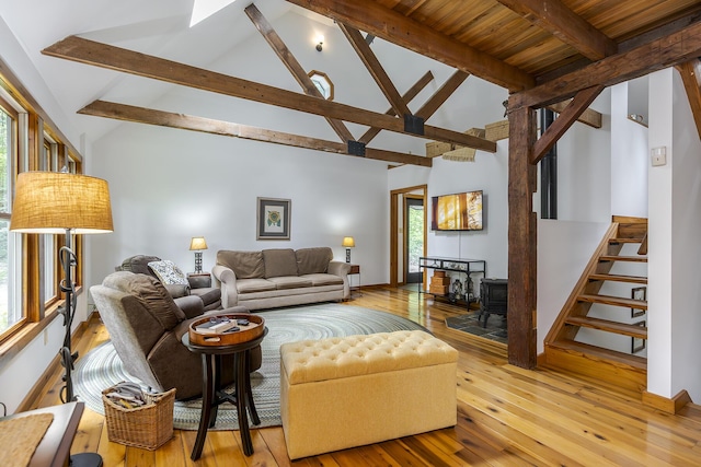224 Pine Valley Rd, Berea, KY 40403 - living room featuring a wood stove, wood-type flooring, beam ceiling, high vaulted ceiling, and stairs