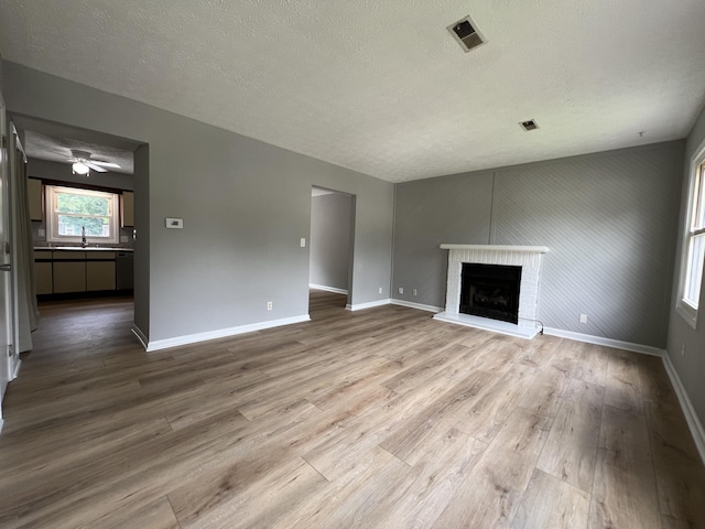 20 Heather Ln, Winchester, KY 40391 - unfurnished living room with wood finished floors, a textured ceiling, a fireplace, and ceiling fan