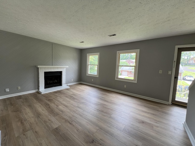 20 Heather Ln, Winchester, KY 40391 - unfurnished living room with a textured ceiling, wood finished floors, plenty of natural light, and a fireplace