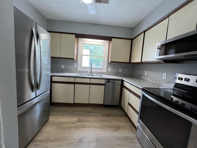 20 Heather Ln, Winchester, KY 40391 - kitchen with appliances with stainless steel finishes, light wood-style floors, light countertops, a textured ceiling, and cream cabinets