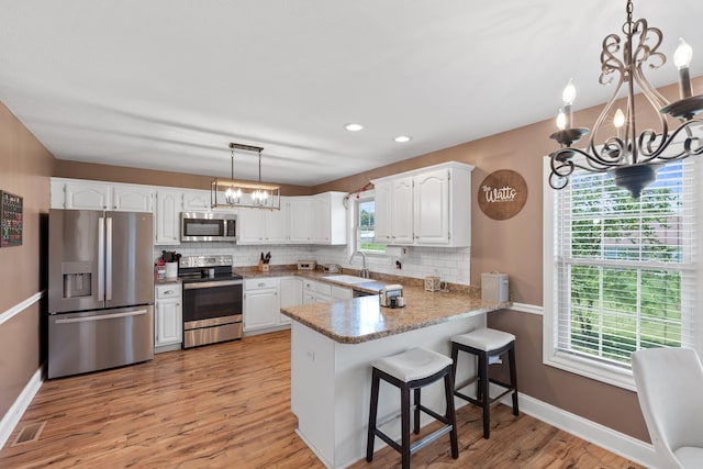 313 Man O War Ct, Lawrenceburg, KY 40342 - kitchen featuring appliances with stainless steel finishes, a chandelier, a peninsula, decorative backsplash, and recessed lighting