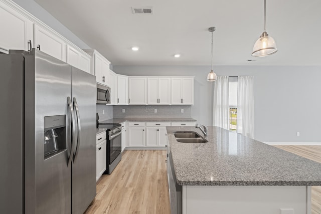 1152 Leanndra Park, Lexington, KY 40511 - kitchen featuring stainless steel appliances, light wood-style flooring, white cabinets, a center island with sink, and decorative backsplash
