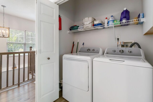 2394 Roberts Bend Rd, Burnside, KY 42519 - laundry area with separate washer and dryer, a chandelier, and light wood-type flooring