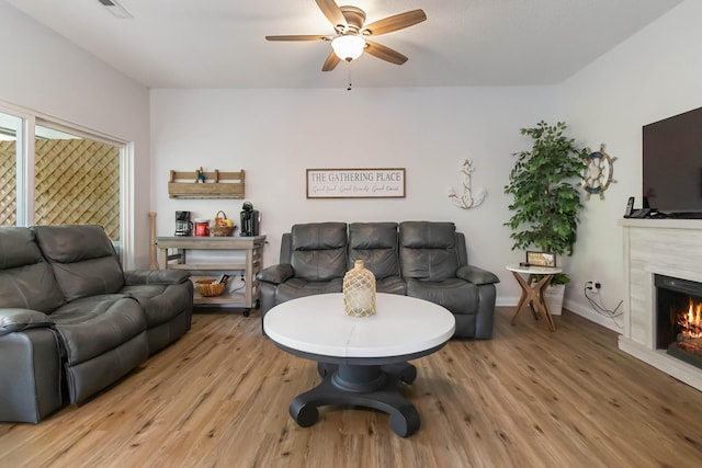 2394 Roberts Bend Rd, Burnside, KY 42519 - living area with light wood finished floors, a ceiling fan, and a fireplace