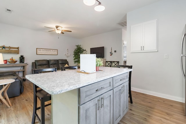 2394 Roberts Bend Rd, Burnside, KY 42519 - kitchen featuring a kitchen bar, light wood-style flooring, and light countertops
