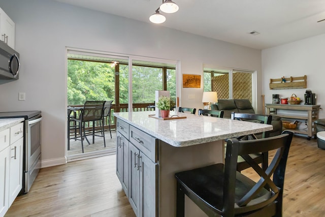 2394 Roberts Bend Rd, Burnside, KY 42519 - kitchen featuring appliances with stainless steel finishes, a kitchen bar, light wood-type flooring, and a kitchen island