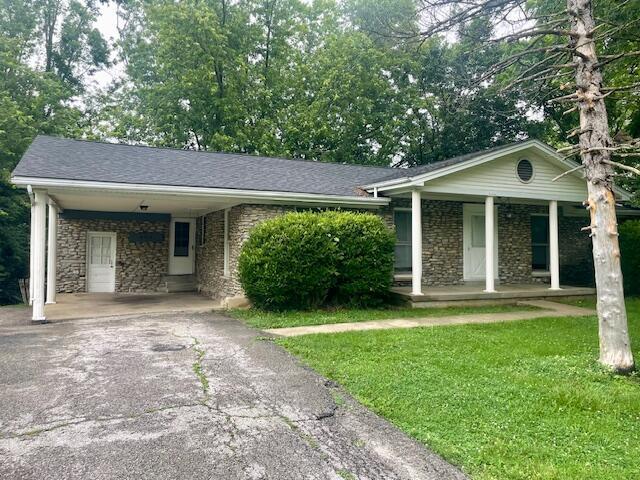 406 Forrest Dr, Lawrenceburg, KY 40342 - single story home featuring asphalt driveway, covered porch, a front lawn, an attached carport, and stone siding