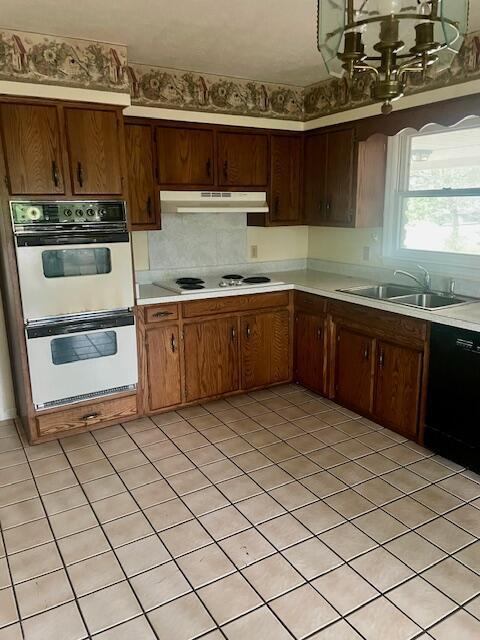 406 Forrest Dr, Lawrenceburg, KY 40342 - kitchen featuring white appliances, under cabinet range hood, light countertops, a chandelier, and light tile patterned floors