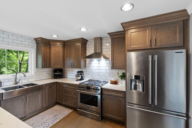 4109 Bridgemont Ln, Lexington, KY 40515 - kitchen with appliances with stainless steel finishes, wall chimney exhaust hood, wood finished floors, backsplash, and recessed lighting