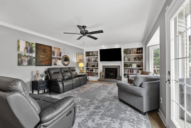 4109 Bridgemont Ln, Lexington, KY 40515 - living room featuring crown molding, ceiling fan, a fireplace with raised hearth, wood finished floors, and built in features