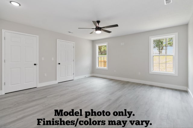 61 Vine St, Corbin, KY 40701 - unfurnished bedroom with multiple windows, light wood-style flooring, and a ceiling fan