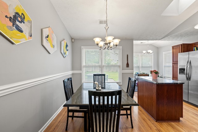 2829 Gateway Park Ln, Lexington, KY 40511 - dining room featuring a chandelier, light wood finished floors, lofted ceiling, and a textured ceiling