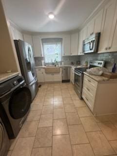 5 Abbey Ln, Middlesboro, KY 40965 - kitchen featuring appliances with stainless steel finishes, decorative backsplash, washer / clothes dryer, and light countertops