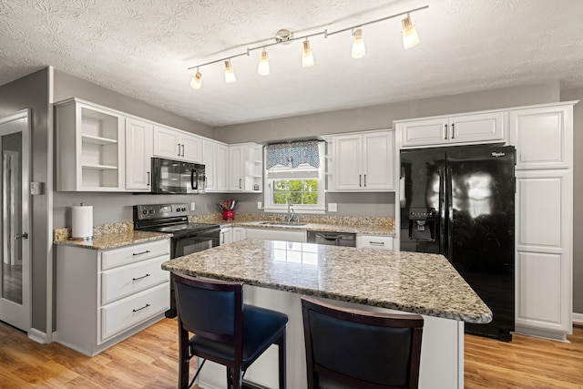 215 New Dixville Rd, Harrodsburg, KY 40330 - kitchen featuring open shelves, black appliances, light wood finished floors, and a textured ceiling