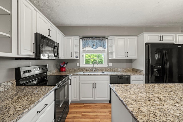 215 New Dixville Rd, Harrodsburg, KY 40330 - kitchen with black appliances, open shelves, light wood-type flooring, white cabinets, and a textured ceiling