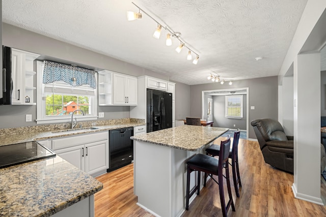 215 New Dixville Rd, Harrodsburg, KY 40330 - kitchen featuring black appliances, open shelves, a kitchen bar, white cabinets, and a textured ceiling