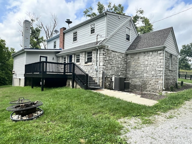 8585 Troy Pike, Versailles, KY 40383 - rear view of property with a fire pit, a wooden deck, a lawn, and stone siding