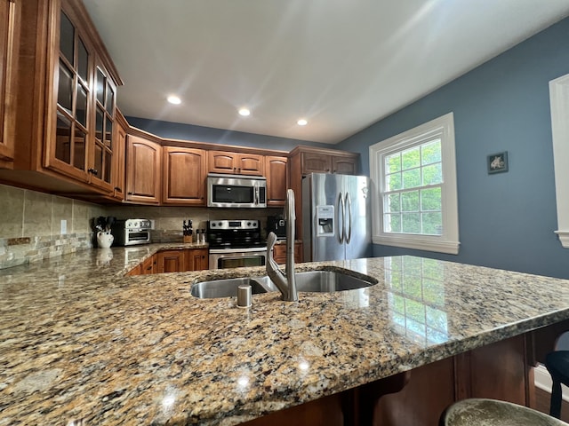 8585 Troy Pike, Versailles, KY 40383 - kitchen featuring stainless steel appliances, glass insert cabinets, light stone countertops, a kitchen bar, and recessed lighting