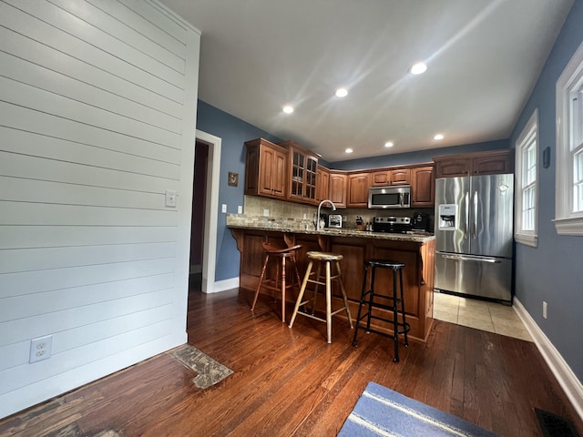 8585 Troy Pike, Versailles, KY 40383 - kitchen with stainless steel appliances, glass insert cabinets, a peninsula, light stone countertops, and a kitchen breakfast bar