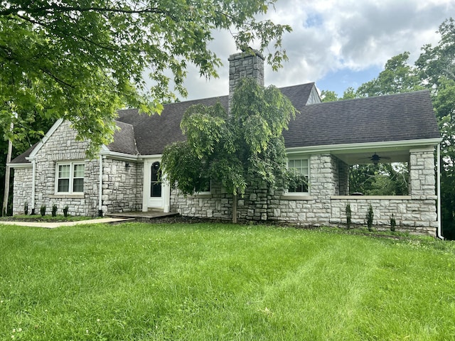 8585 Troy Pike, Versailles, KY 40383 - view of front of house featuring stone siding, a chimney, a front yard, and a shingled roof
