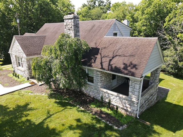 8585 Troy Pike, Versailles, KY 40383 - view of home's exterior featuring stone siding, roof with shingles, a chimney, and a lawn