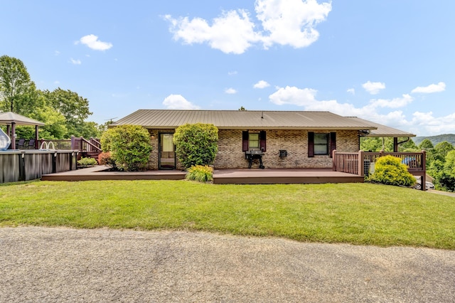 72 Blevins Ln, Vanceburg, KY 41179 - back of house with a metal roof, brick siding, a lawn, and a wooden deck