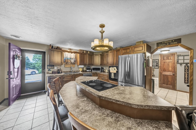 72 Blevins Ln, Vanceburg, KY 41179 - kitchen with appliances with stainless steel finishes, light tile patterned floors, a textured ceiling, a chandelier, and a kitchen bar