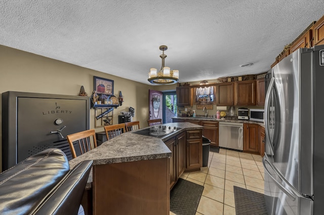 72 Blevins Ln, Vanceburg, KY 41179 - kitchen with appliances with stainless steel finishes, dark countertops, a chandelier, a center island, and light tile patterned flooring