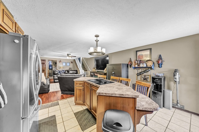 72 Blevins Ln, Vanceburg, KY 41179 - kitchen with freestanding refrigerator, black electric stovetop, light tile patterned floors, open floor plan, and a kitchen island