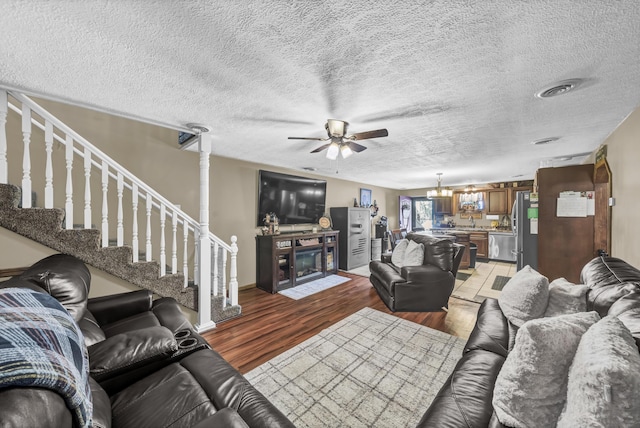72 Blevins Ln, Vanceburg, KY 41179 - living area with ceiling fan, a fireplace with flush hearth, light wood-type flooring, a textured ceiling, and stairway