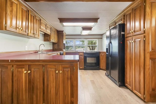 1751 Piney Grove Rd, Somerset, KY 42501 - kitchen with black appliances, a peninsula, light wood finished floors, and brown cabinets
