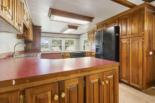 1751 Piney Grove Rd, Somerset, KY 42501 - kitchen featuring black fridge, a peninsula, brown cabinetry, light wood-style floors, and ornamental molding