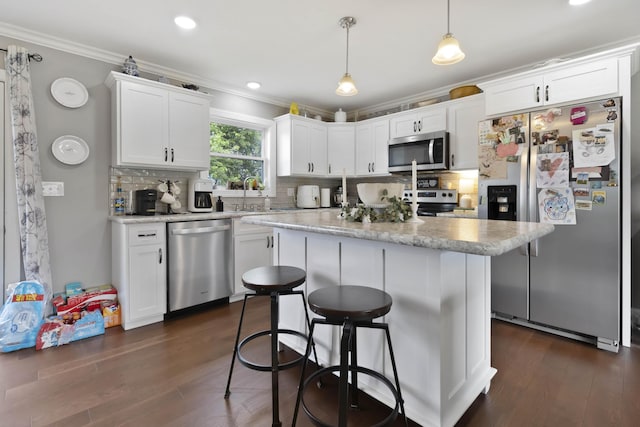 81 Grand Crossing Ct, Somerset, KY 42503 - kitchen with appliances with stainless steel finishes, ornamental molding, backsplash, white cabinets, and a kitchen breakfast bar
