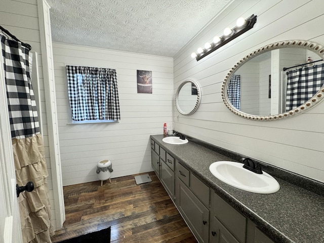 190 Keeneland Trl, Corbin, KY 40701 - bathroom featuring wooden walls, wood finished floors, double vanity, a textured ceiling, and curtained shower