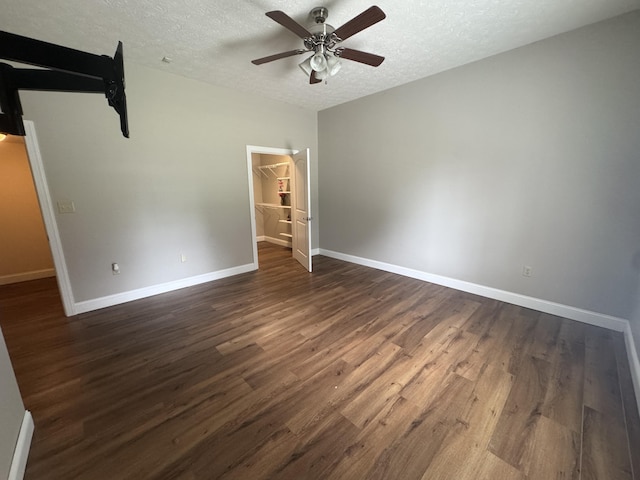 1459 Kit Cowan Rd, Somerset, KY 42501 - unfurnished bedroom featuring a textured ceiling, dark wood finished floors, a walk in closet, a closet, and ceiling fan
