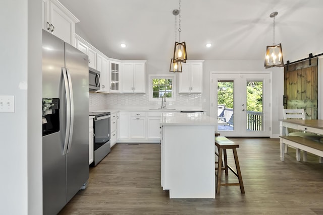 168 Kentucky Ln, Pine Knot, KY 42635 - kitchen featuring stainless steel appliances, a kitchen breakfast bar, a center island, decorative backsplash, and light countertops